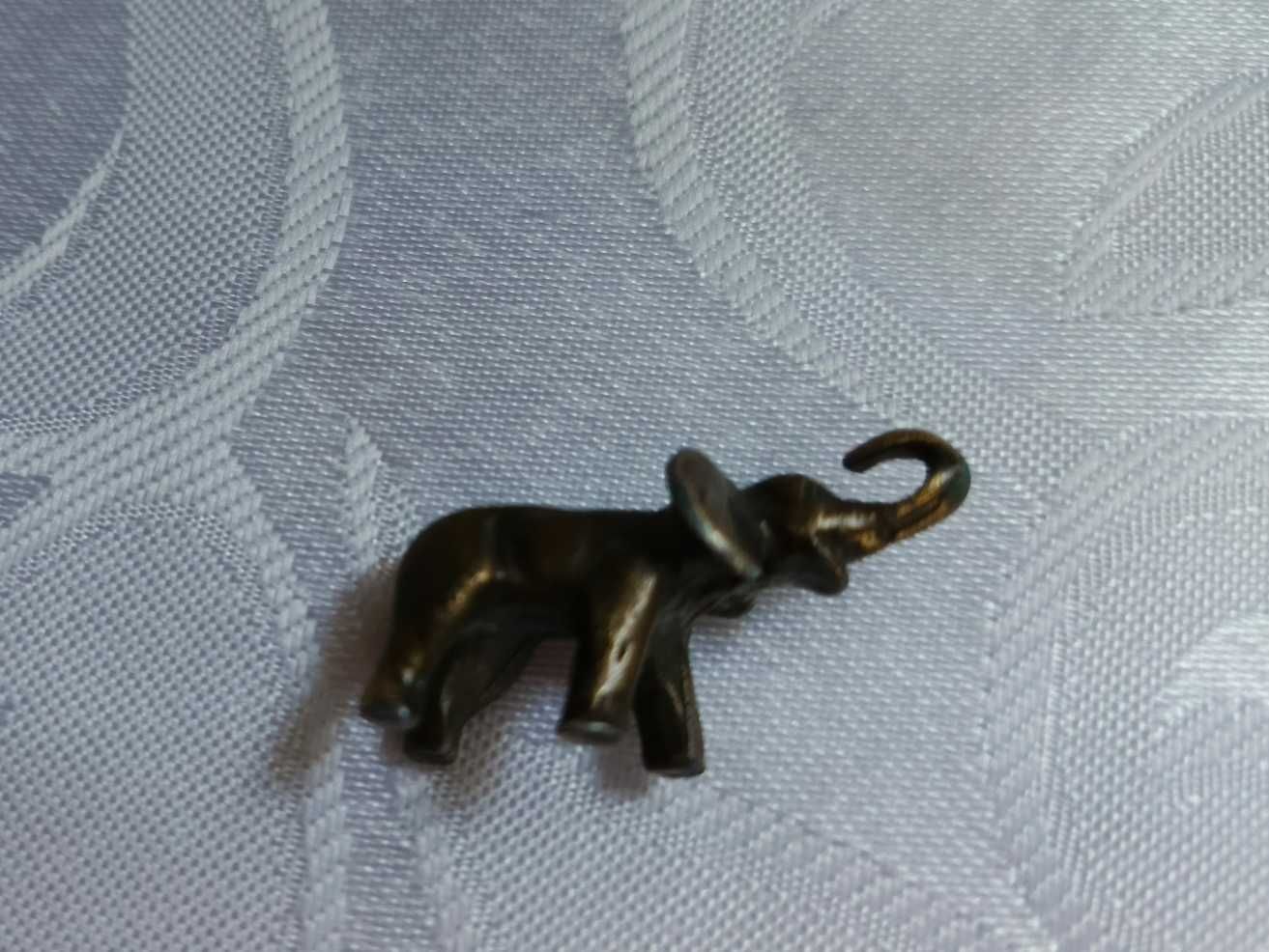 Figurka mini słonika z podniesioną trąbą.