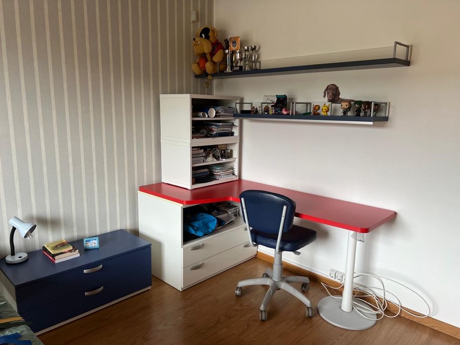 Quarto com cama , mesa de cabeceira e secretaria com estante