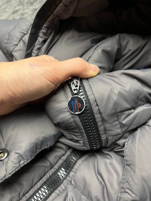 довгий пуховик Moncler Moka сірого кольору.