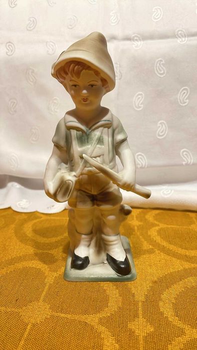 Figurka z porcelany przedstawiająca chłopca. Sygnowana