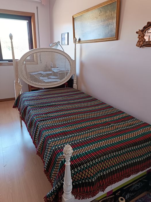 Cama de solteiro antiga em madeira branca, cabeceira em rede de palhin