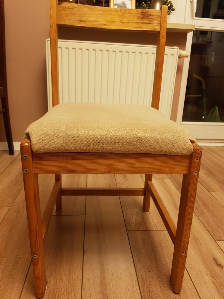 Krzesło sosnowe z miękkim siedziskiem w kolorze beżu.