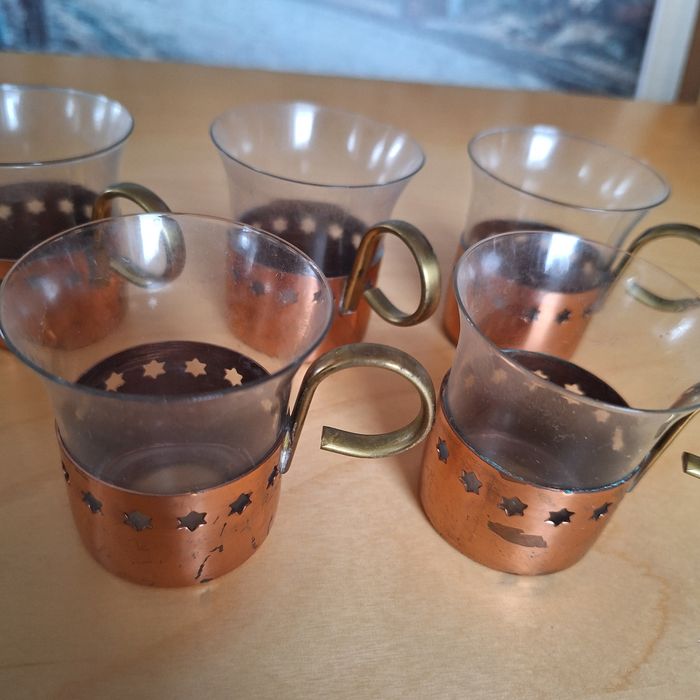 Małe szklanki w miedzianych koszyczkach