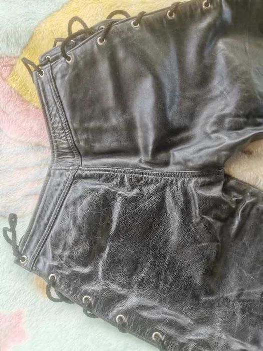 Calças com atilhos em pele