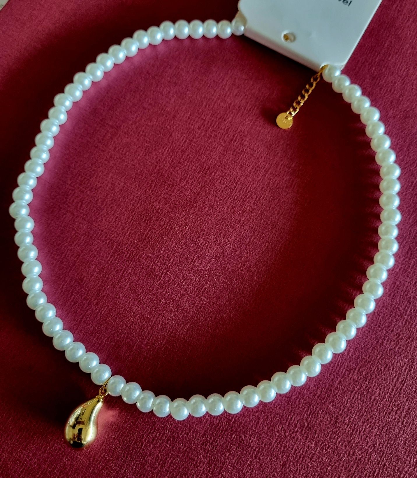 Colar de pérolas com acabamento e pingente em forma de gota, em aço.