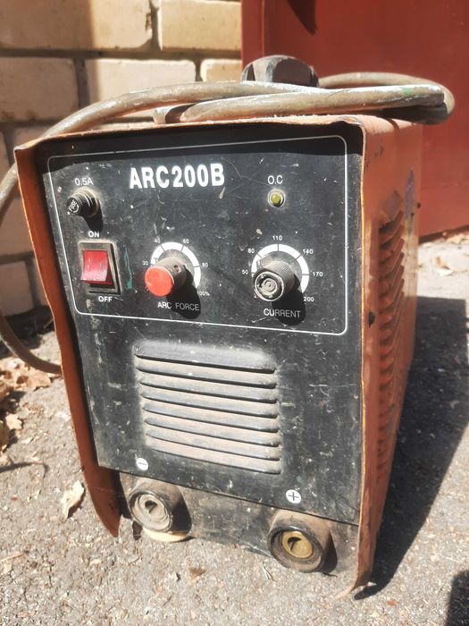 Сварочный аппарат с  кабелями,  держателем электродов и маской.