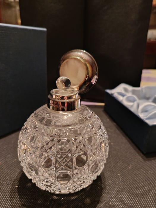 Флакон для духов с серебряной крышкой.