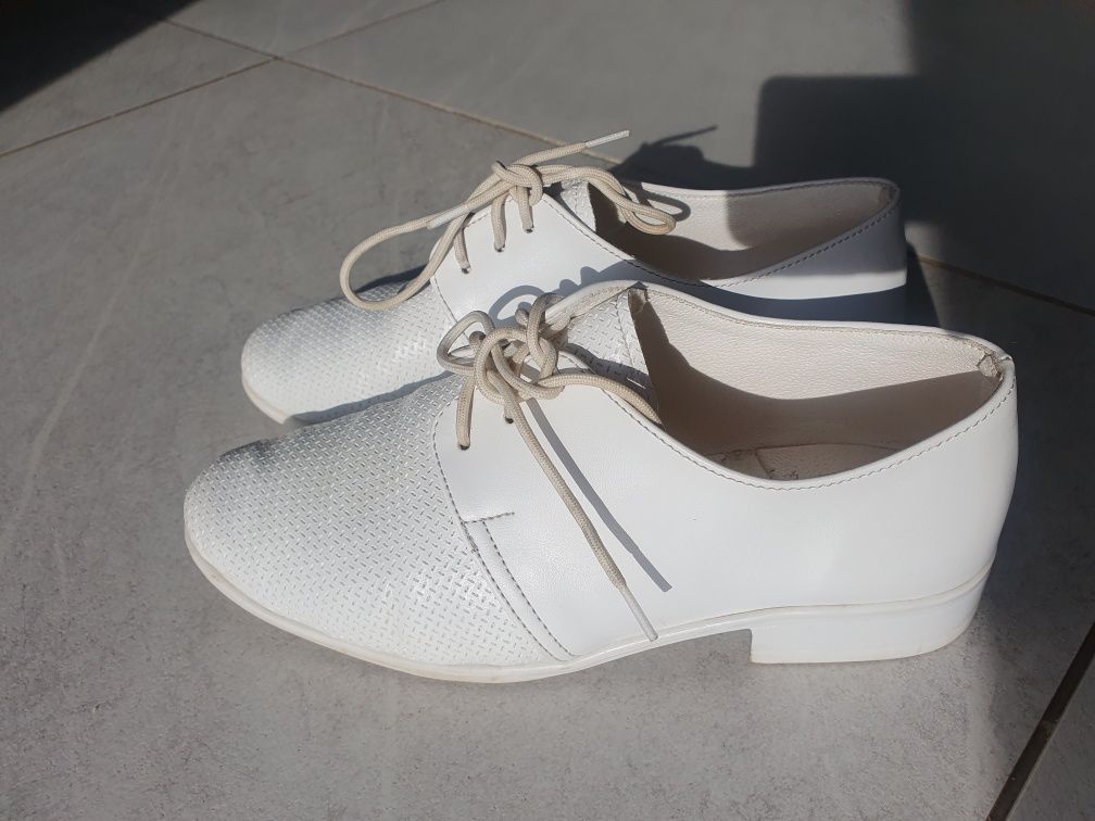 Białe, chłopięce buty komunijne.