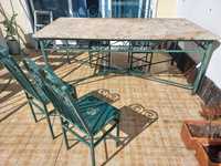 Conjunto mesa com tampo em pedra e quatro cadeiras em ferro