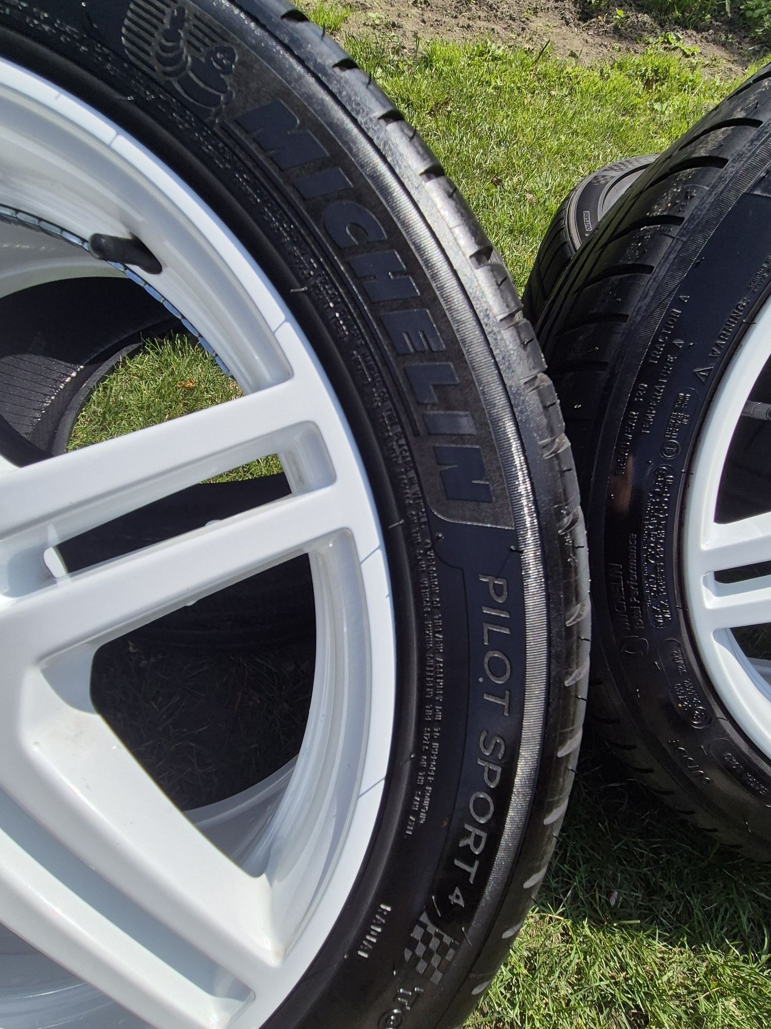 Komplet białych felg z oponami michelin.