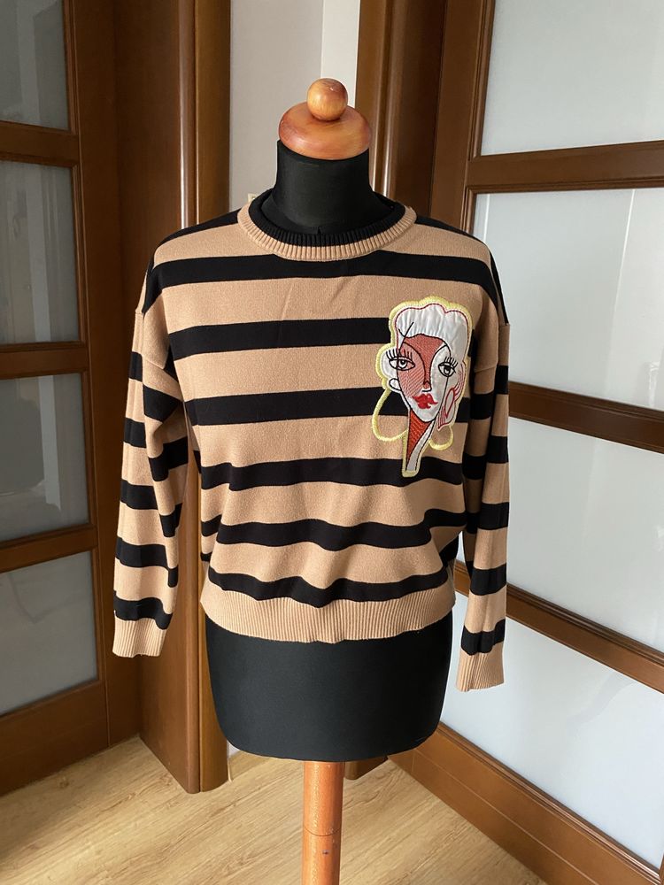 Damski gruby sweter w paski z naszywką