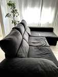 Sofá cinza escuro com chaise longue e arrumação