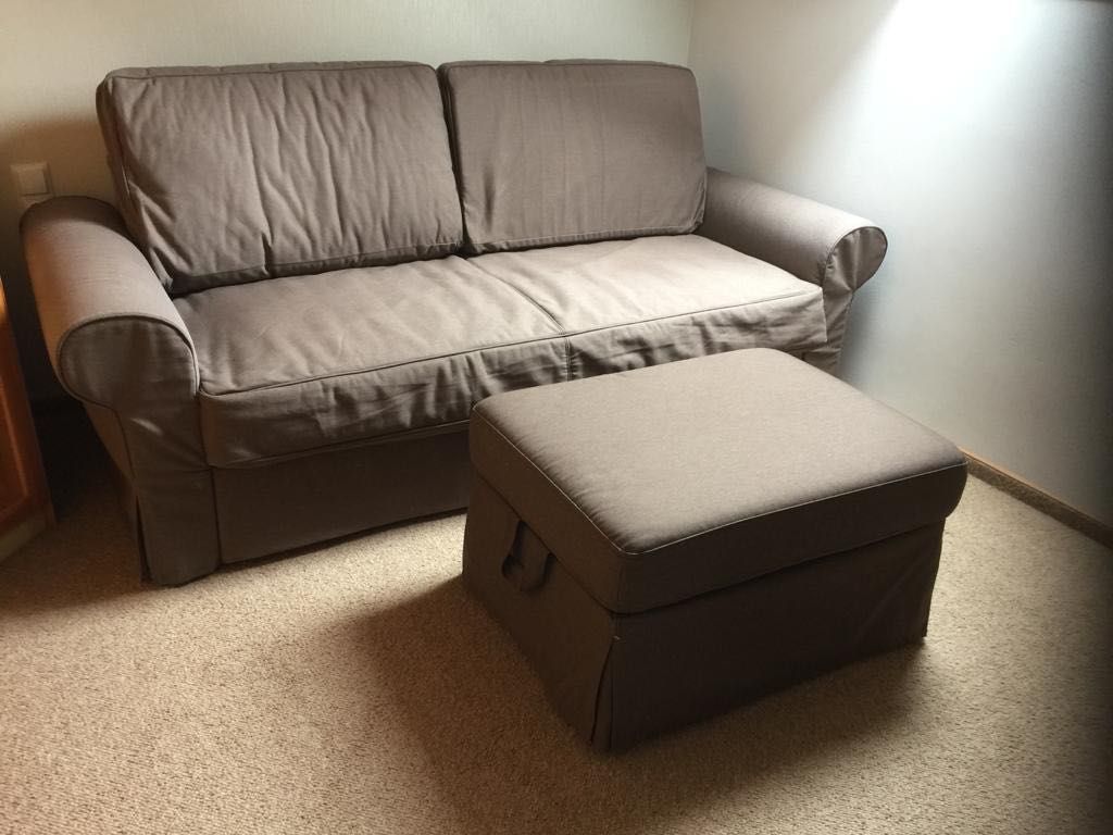 brązowa prawie nowa sofa oraz pufa