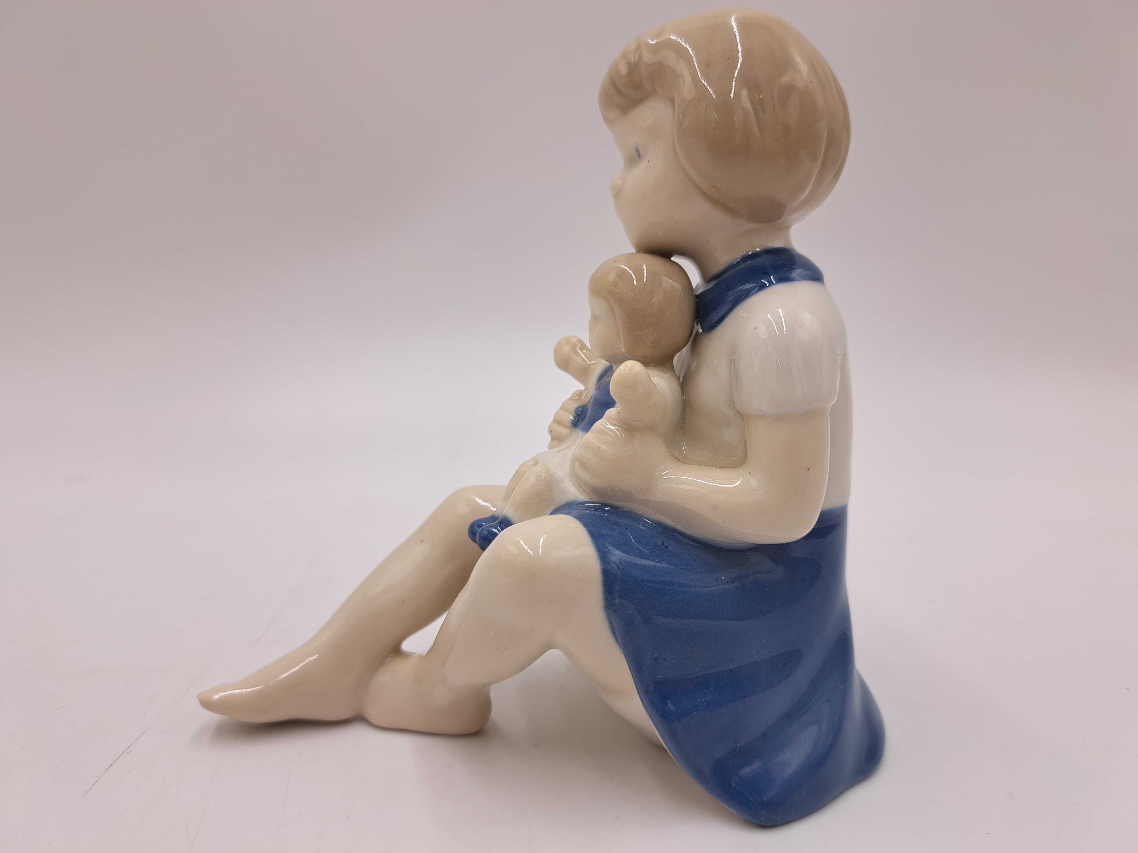 Figurka porcelanowa dziewczynka z lalką na kolanach GDR Wagner&Apel