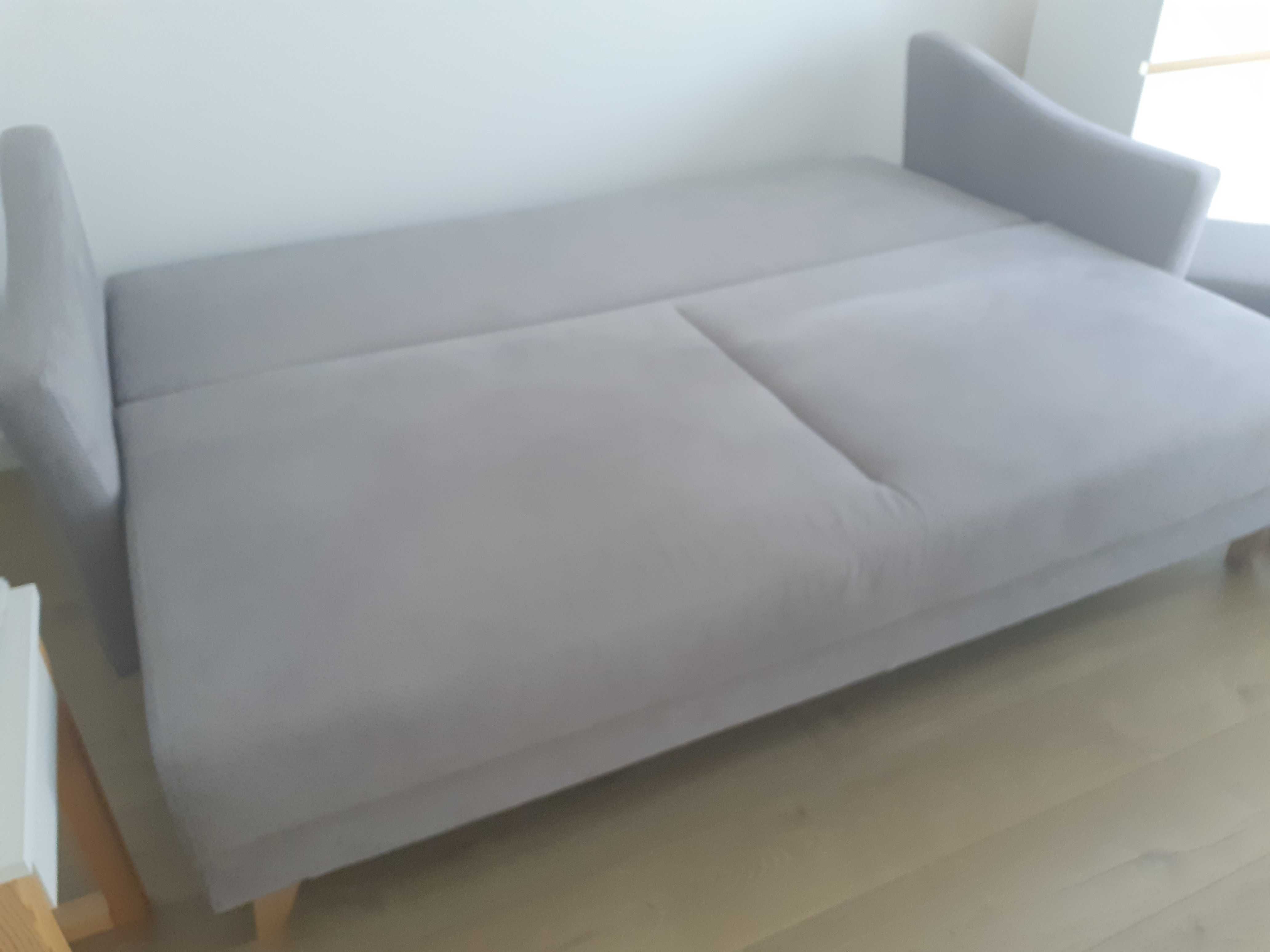 Szara sofa rozkładana z pojemnikiem na pościel
