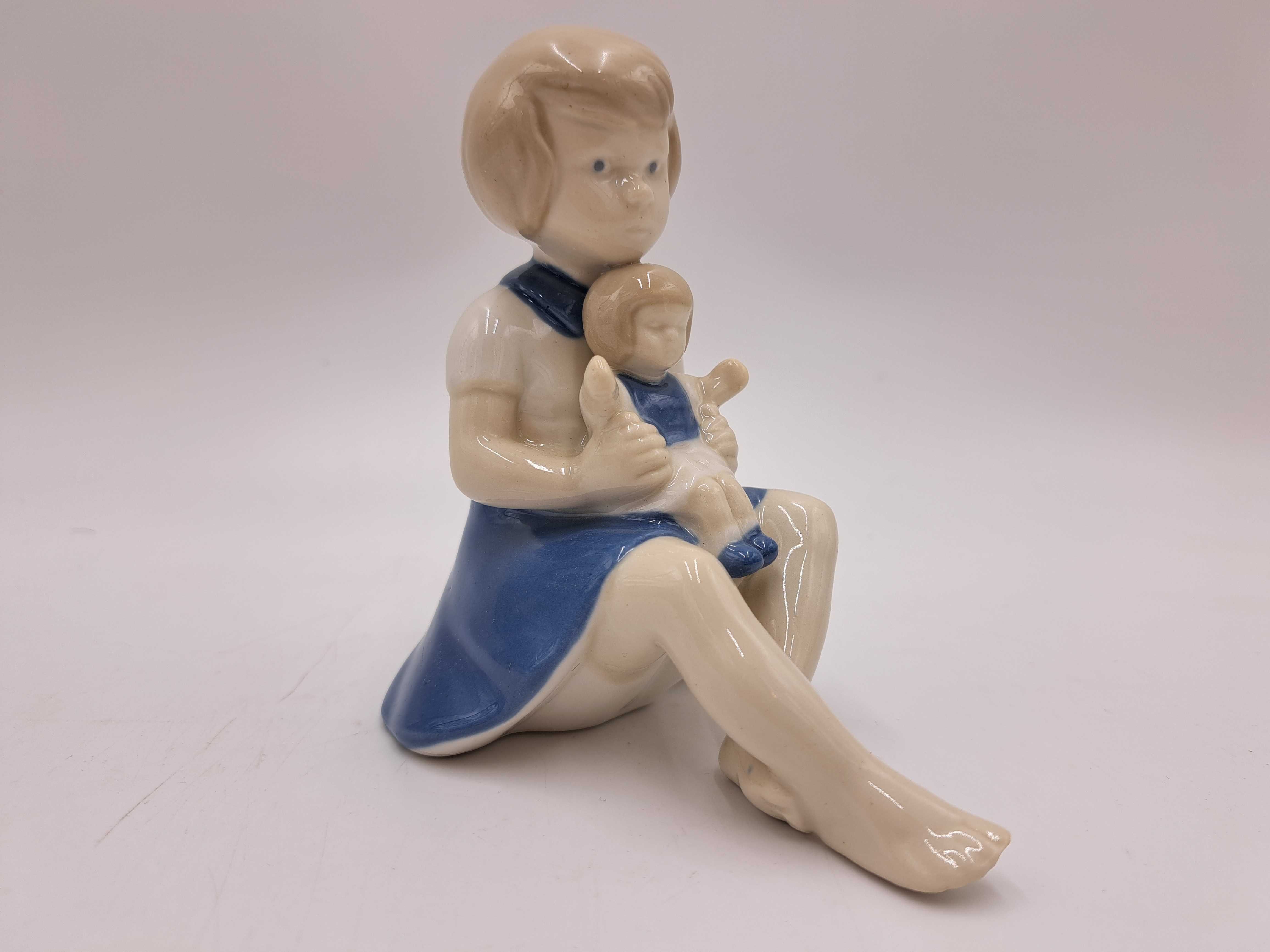 Figurka porcelanowa dziewczynka z lalką na kolanach GDR Wagner&Apel