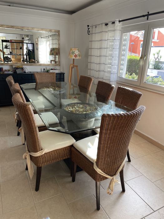 Mesa de jantar de vidro com cadeiras de verga