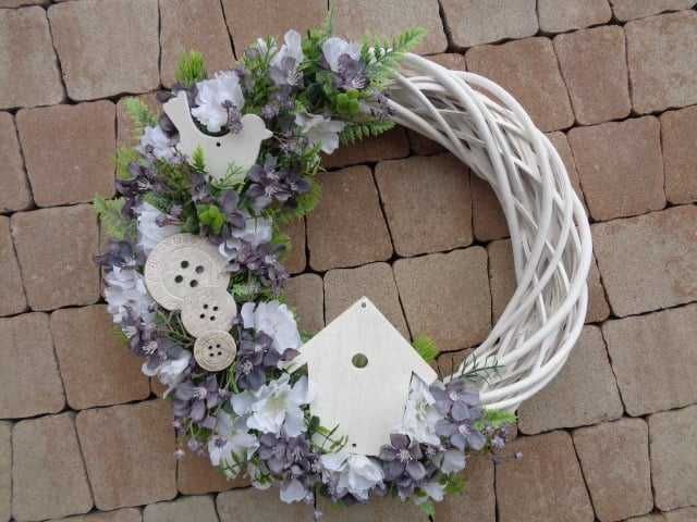Biały wiklinowy wianek z drewnianymi ozdobami i kwiatami sztucznymi