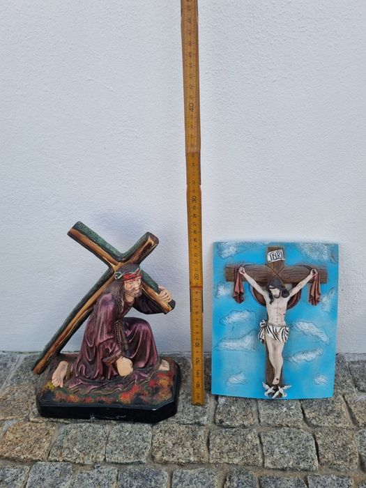Vendo duas peças  Cristo  com cruz às  costas e outra na cruz.