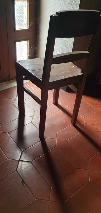 Cadeira antiga em madeira maciça, resistente e estável.