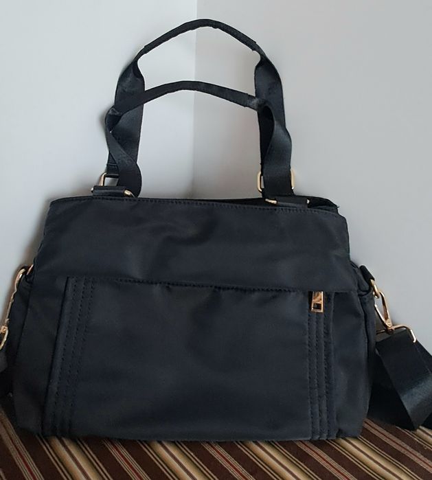 Carteira preta em tecido impermeável com várias divisórias, pratica e