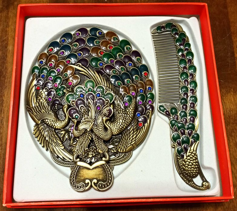 Женское карманное зеркало в виде павлина с зеленым гребнем.