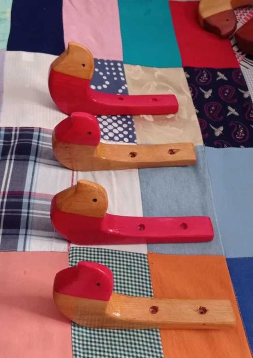 Conjunto de quatro cabides em pinho.