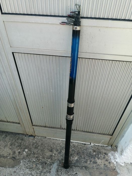 Uma cana de pesca usada pronta a usar e um carreto estão adicional