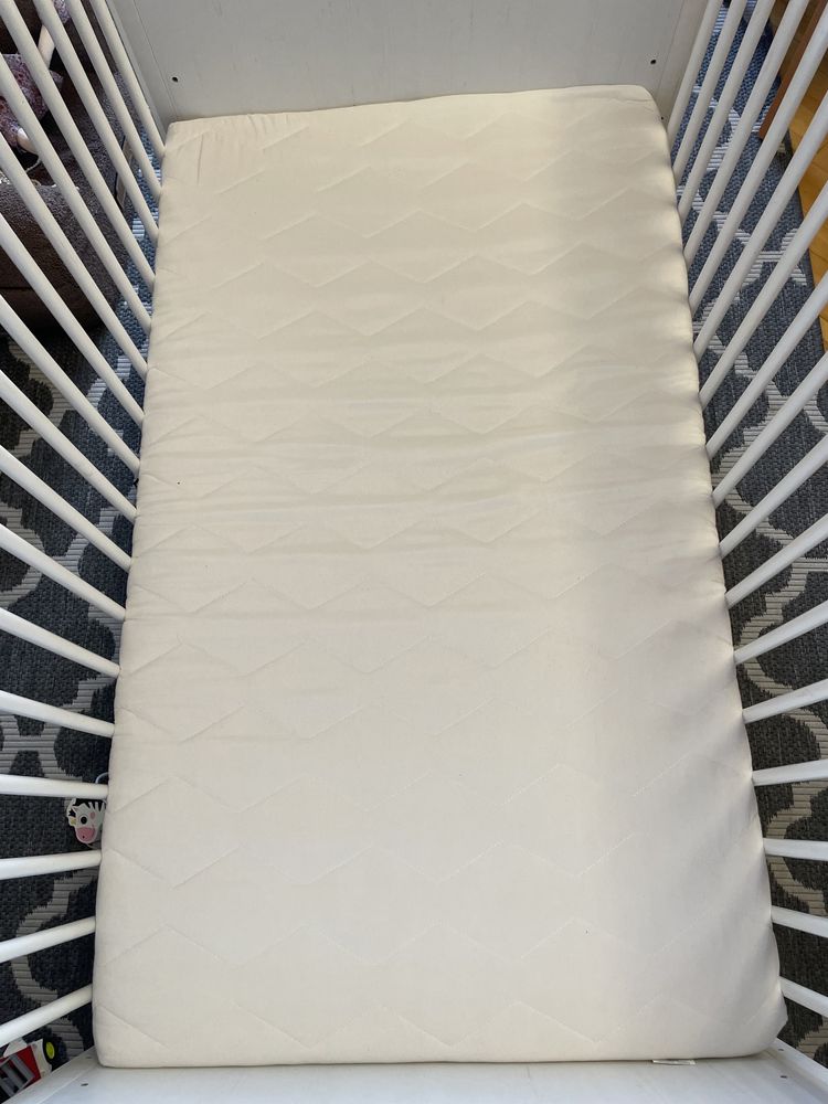 Białe łóżeczko z materacem i przewijakiem