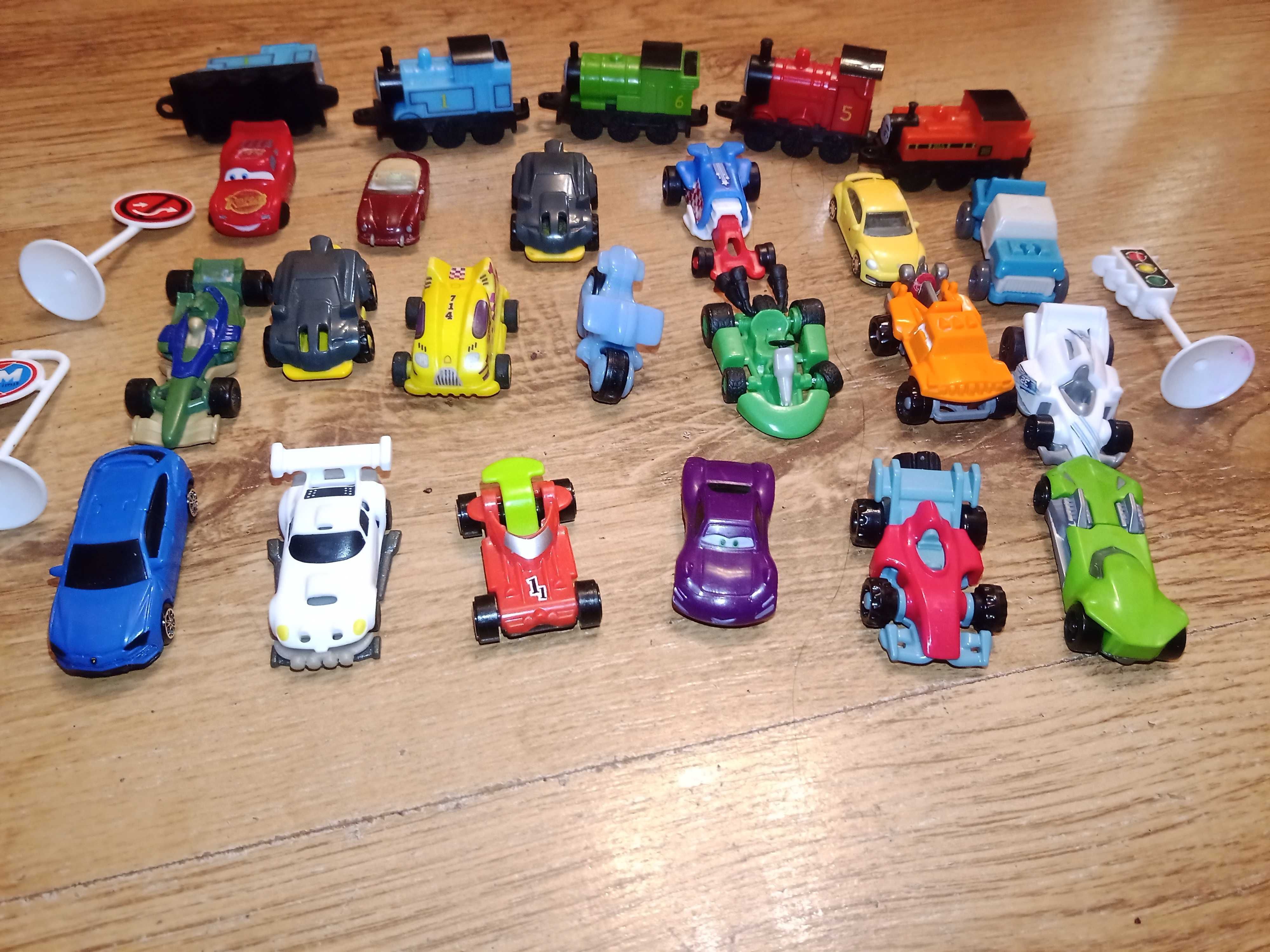 Małe plastikowe samochody i lokomotywy