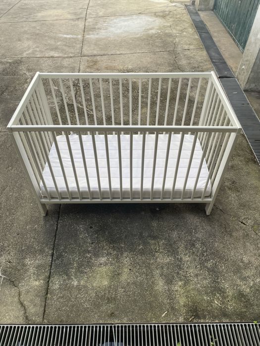 Cama de bebé com colchão.