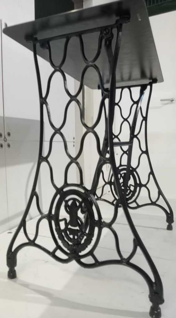 Mesa de vidro com armação de estrutura de máquina de costura.