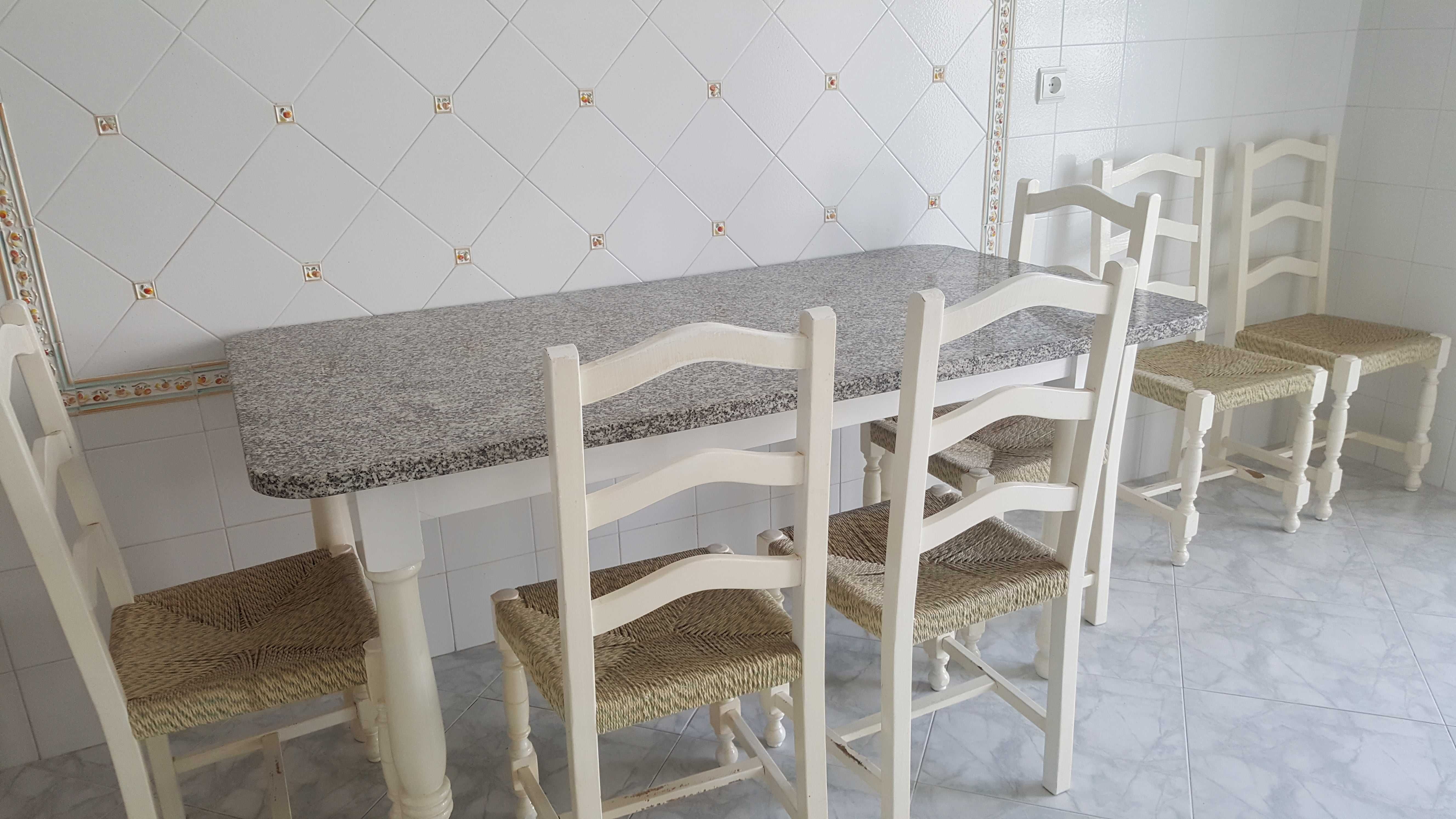 Mesa com tampo de granito e cadeiras de cozinha