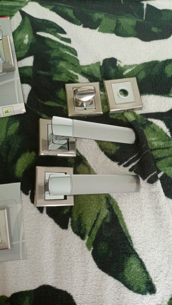 Dwie srebrne klamki WC i pokój z rozetami