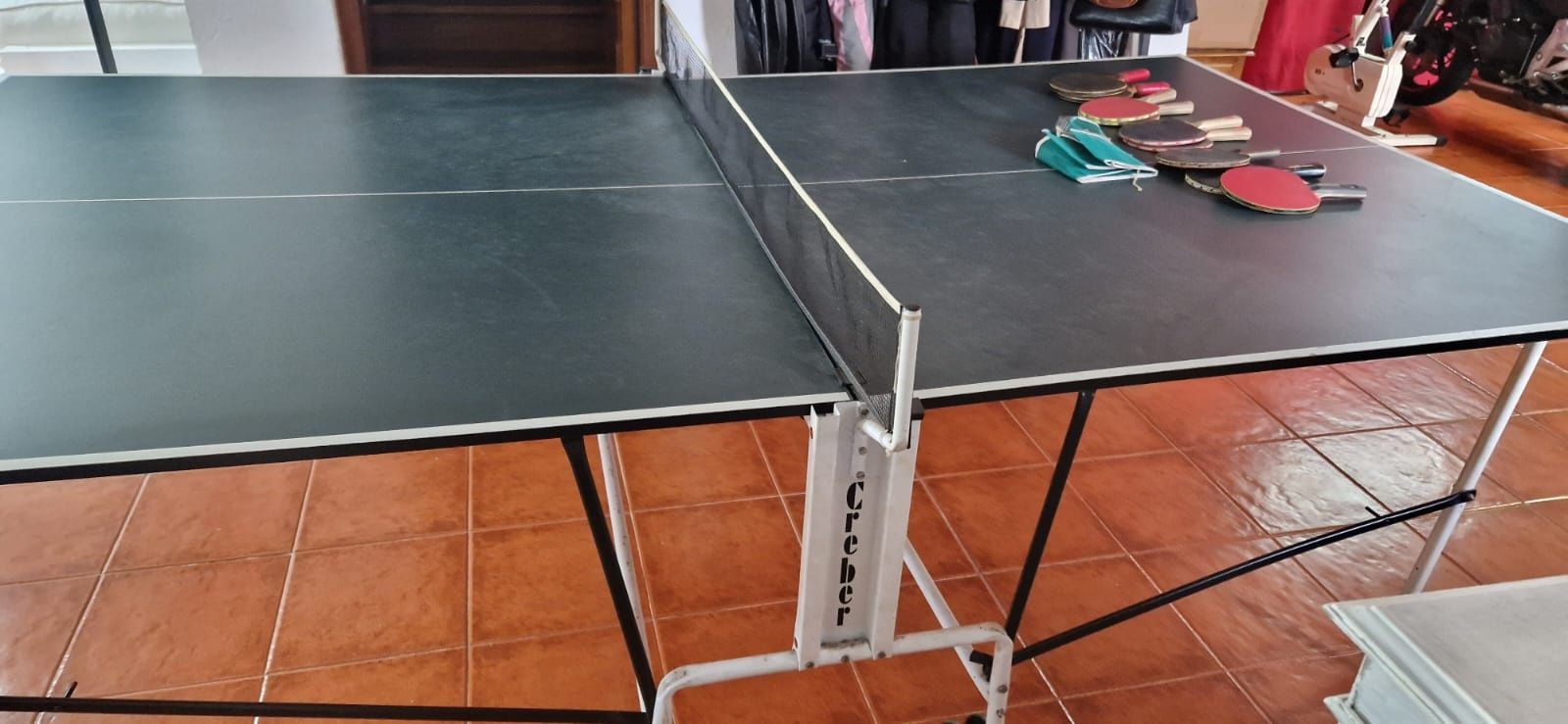 Mesa de ping pong com várias raquetes