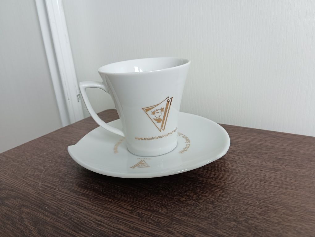 Filiżanka ze spodkiem. Logo Wyższa szkoła kosmetologii Anieli Goc