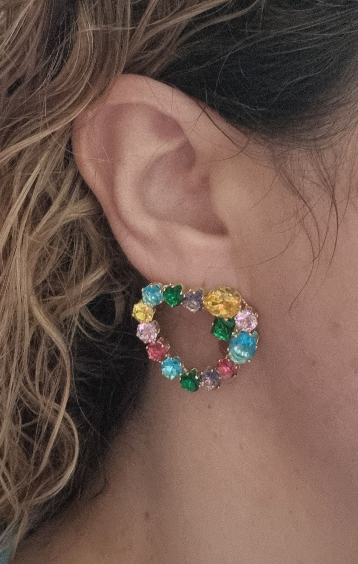 Brincos dourados, de pico, com pedras de vidro coloridas.