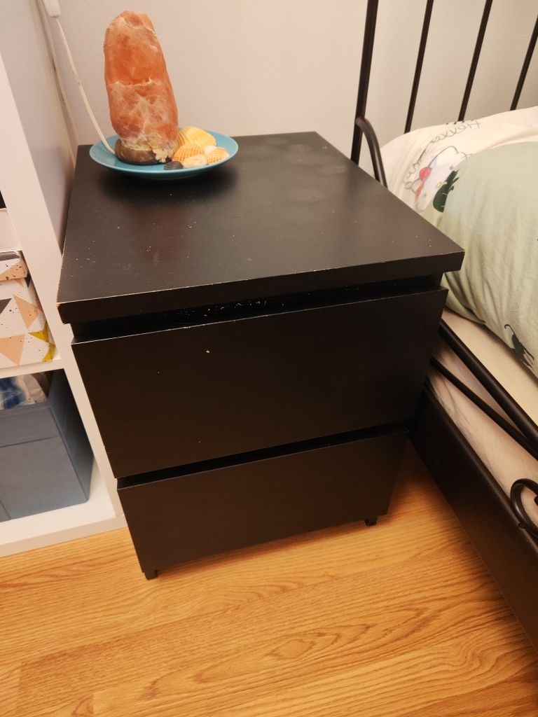 Cama de ferro preta com colchões e mesa de cabeceira