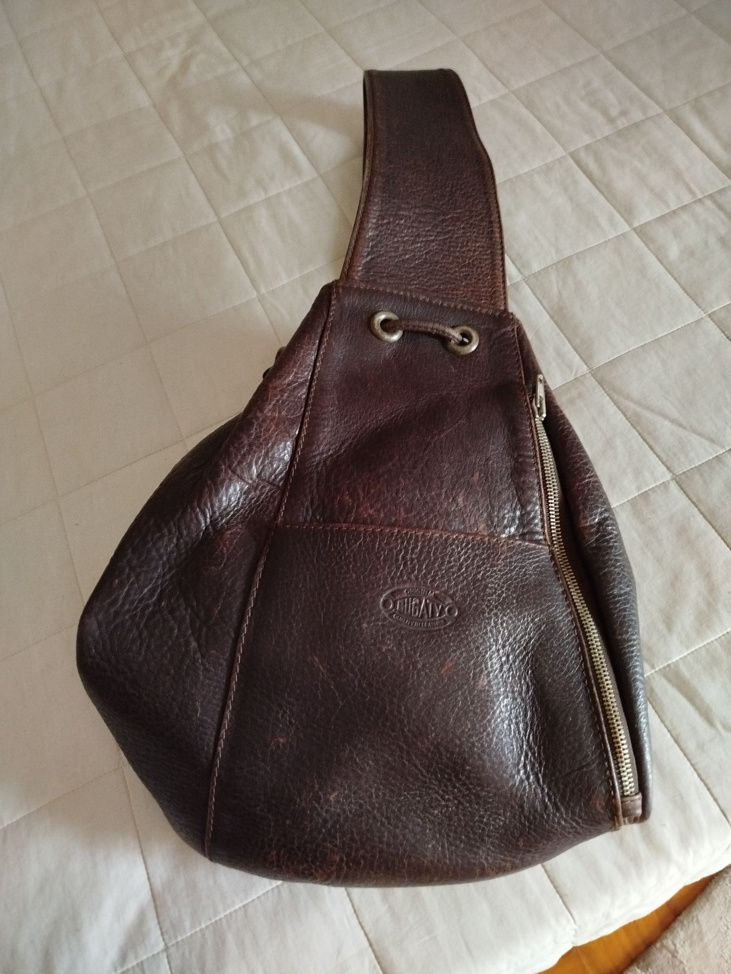 Mochila em pele castanha e bolsa preta . Ambas em pele