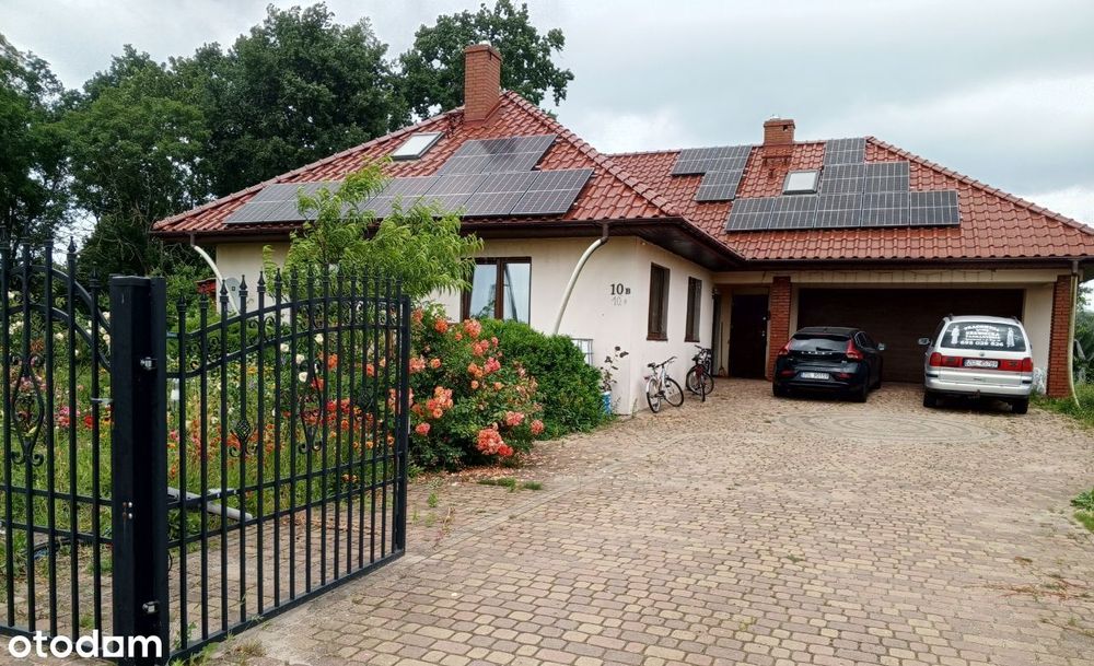 Dom dwupokoleniowy z poddaszem użytkowym i podwójnym garażem .