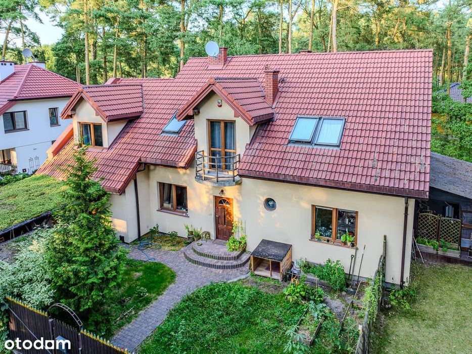 Józefów, dom wolnostojący otoczony sosnami.