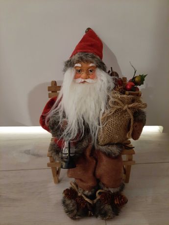 Piękny Mikolaj siedzący na ławce figurka, ozdoba Boże Narodzenie