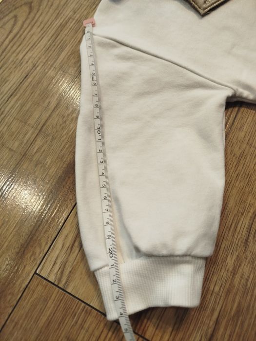 Biała bluza bawełna 80 86 z ozdobną odpinaną dekoracja na dekolcie.