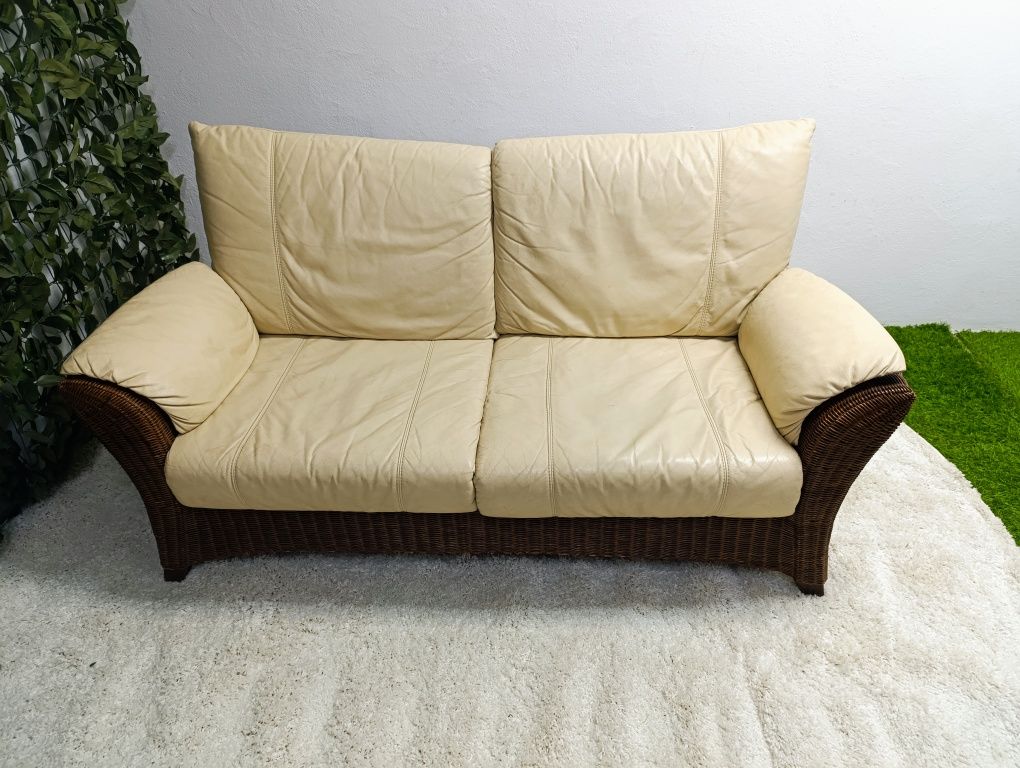 Piekna sofa rattanowa z poduchami ze skóry naturalnej.