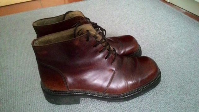 Dois pares botas em pele um pretas, outro castanhas