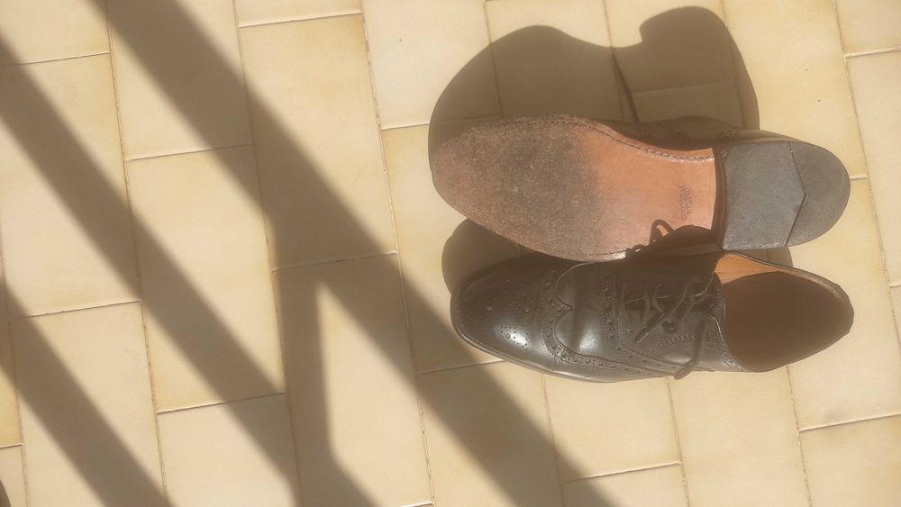 Sapatos pretos de atacadores