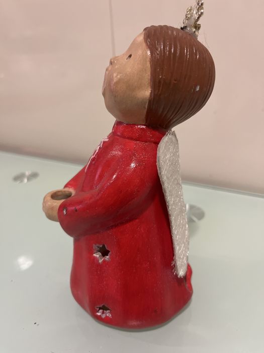 Anjo com suporte para vela tem desenhado buracos em forma de estrla po