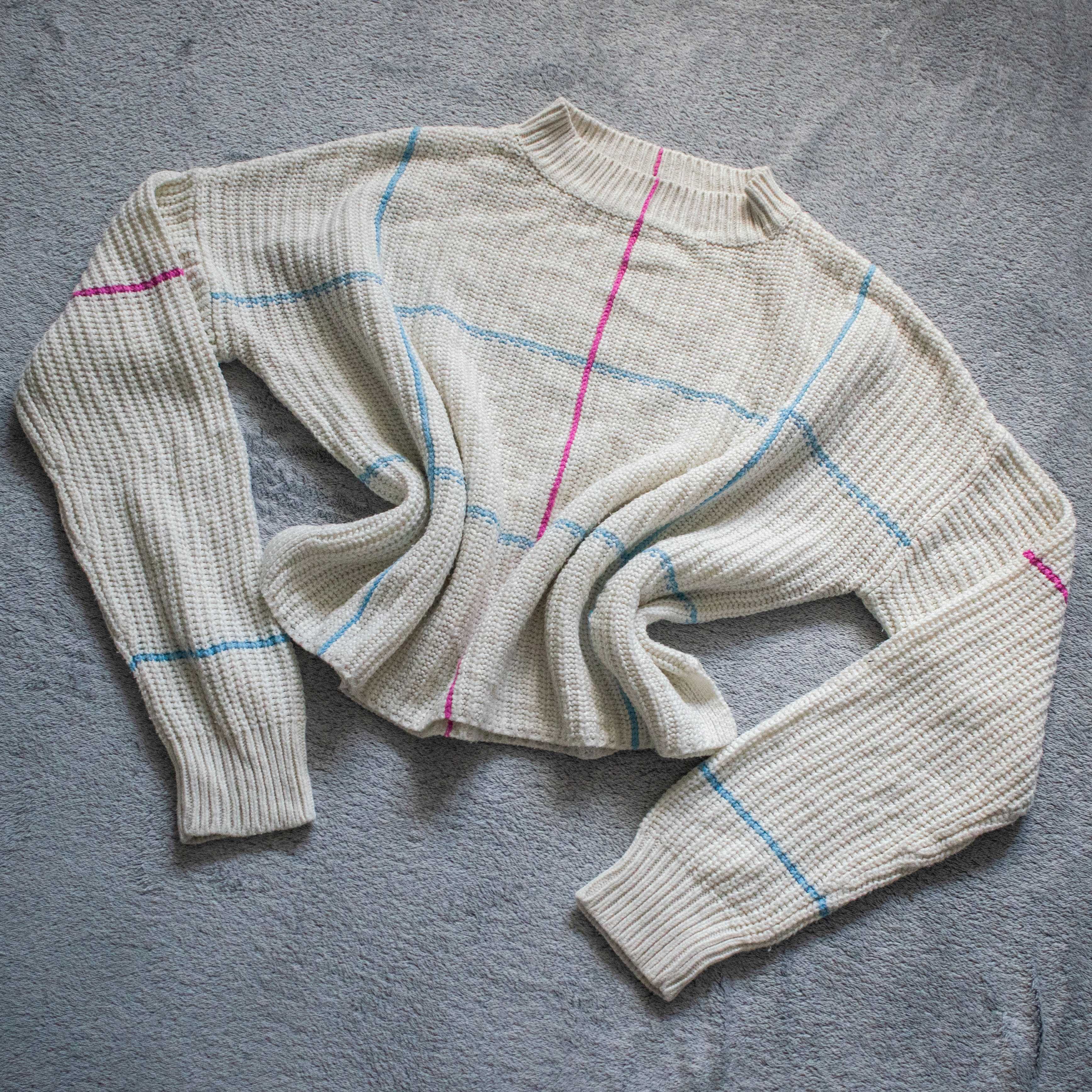 Kremowy sweter w kolorowe linie – casualowy i stylowy