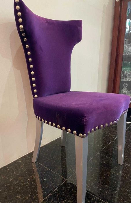 Cadeira moderna em veludo roxo com tachas metálicas de exposição