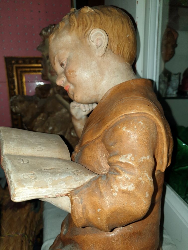 Encantadora antiga escultura de um rapaz com livro em faiança